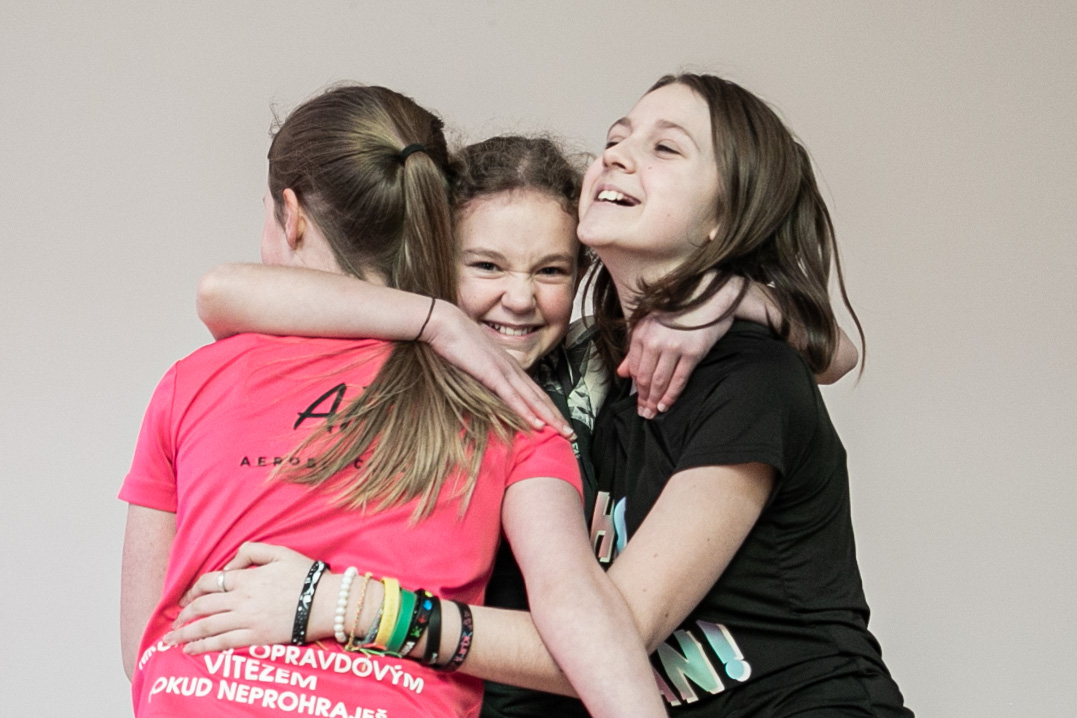 Tři žákyně ve vzájemném objetí.