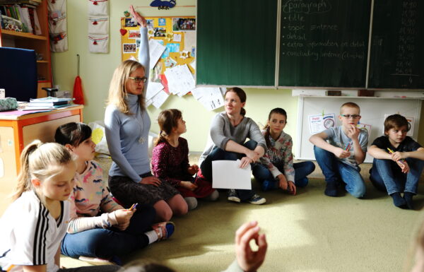 Žákyně se hlásí se zvednutou rukou.