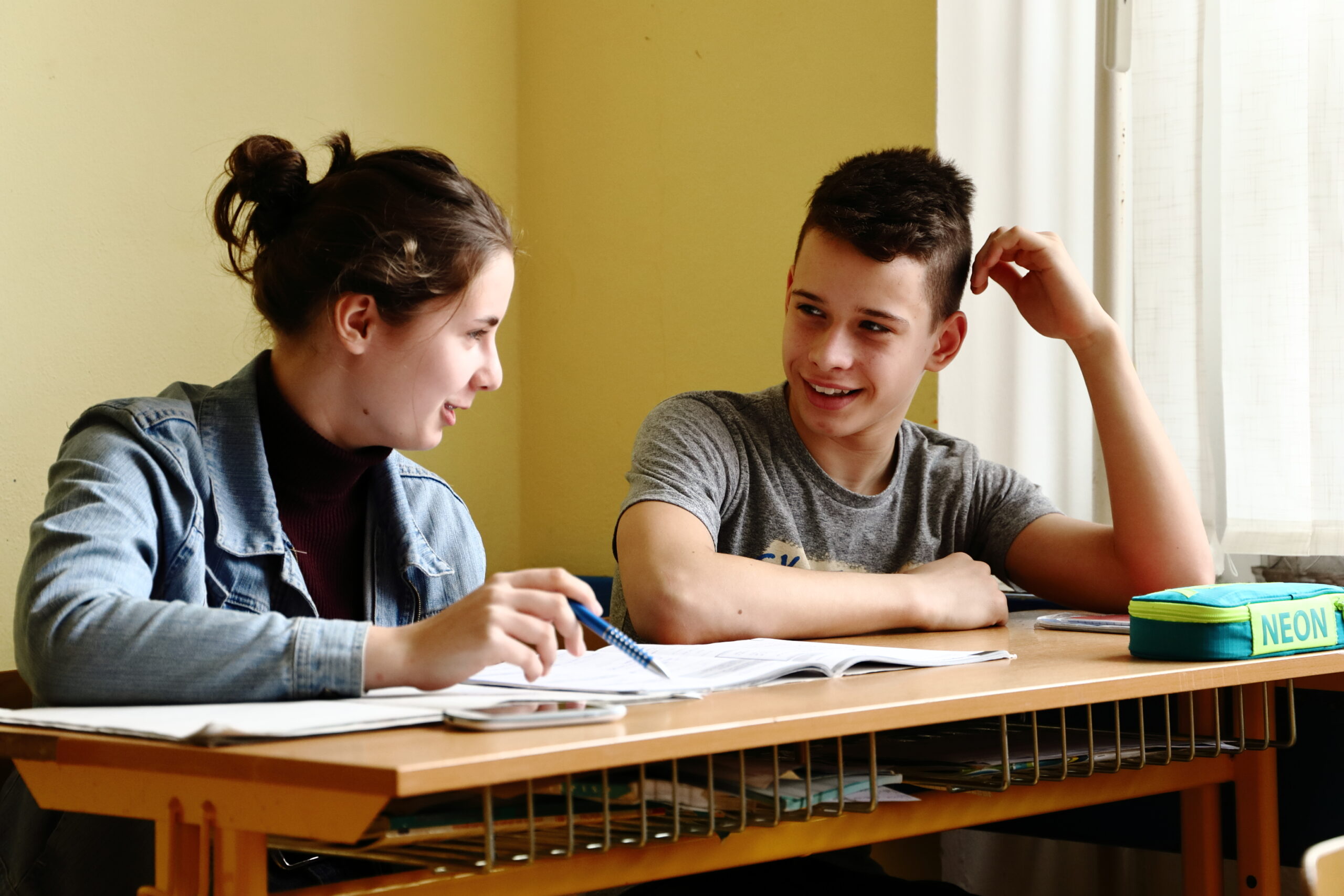 Žák a žákyně sedí v lavici